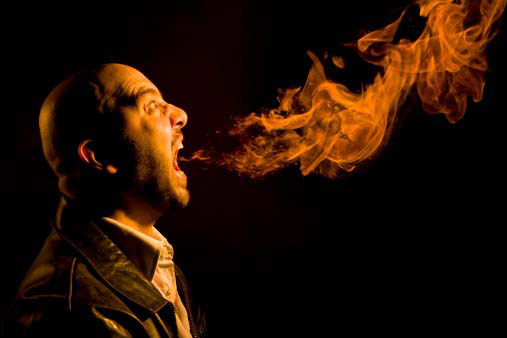 man breathing out fire obnoxious because of heartburn